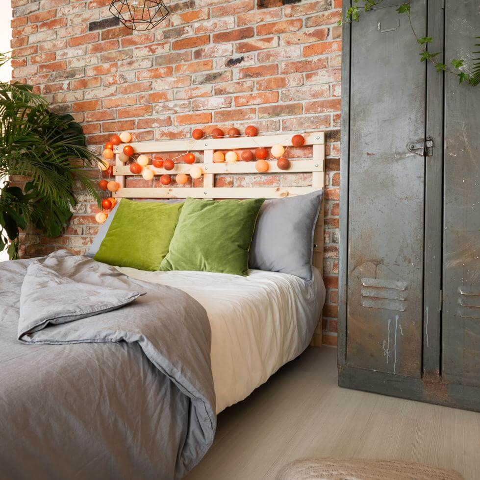 Rustic room with nice bed and bricks and overall vintage look