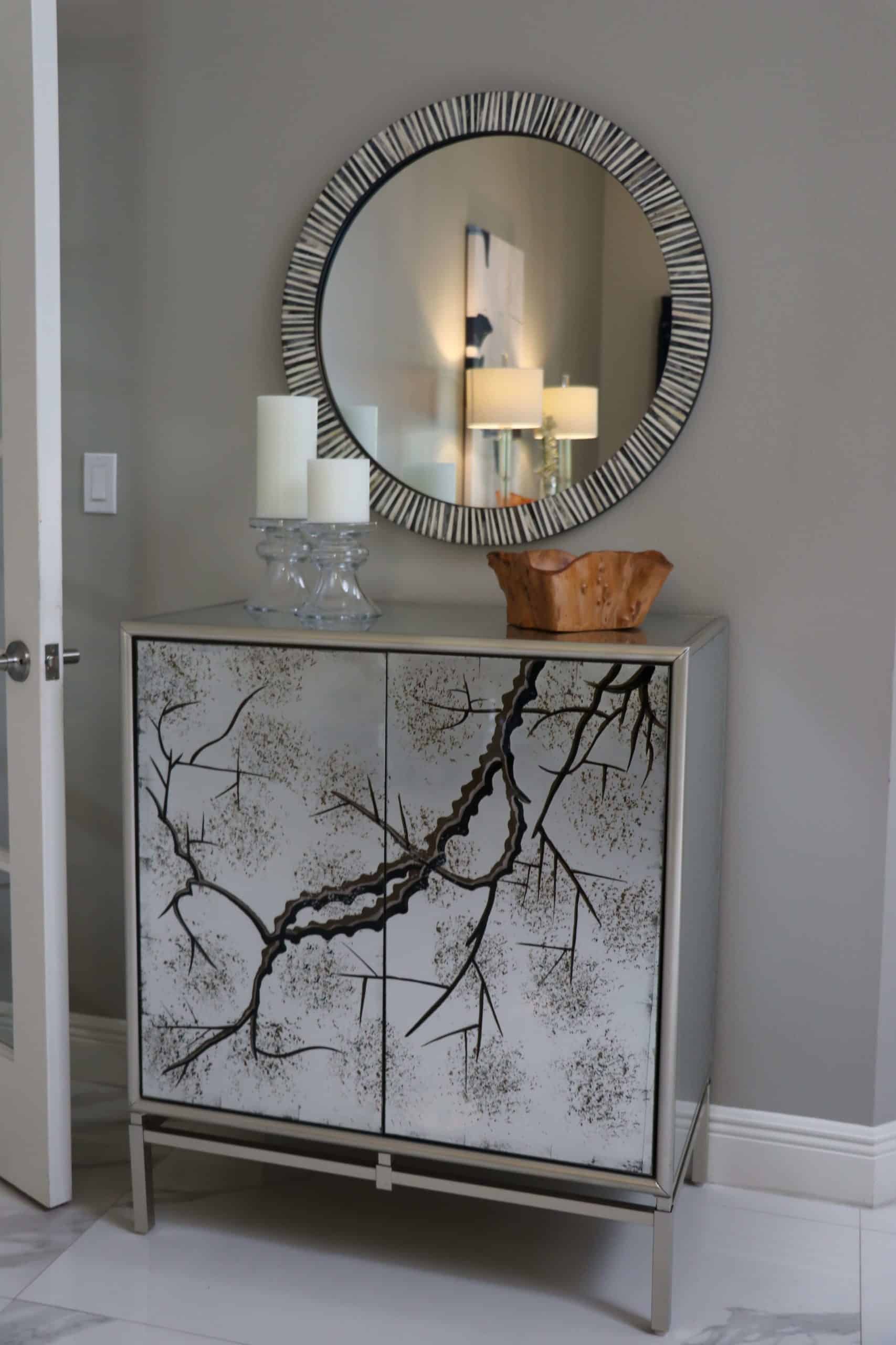 Custom cabinet with an elegant design next below a circular mirror